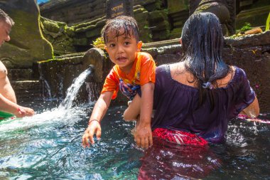 BALI, INDONEZYA - 28 Şubat 2020: Bali halkı Endonezya 'nın Bali kentindeki Pura Tirta Empul Tapınağı' ndaki kutsal havuzda dua ediyor