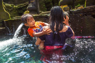 BALI, INDONEZYA - 28 Şubat 2020: Bali halkı Endonezya 'nın Bali kentindeki Pura Tirta Empul Tapınağı' ndaki kutsal havuzda dua ediyor