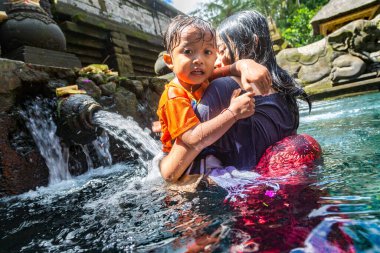 BALI, INDONEZYA - 28 Şubat 2020: Bali halkı Endonezya 'nın Bali kentindeki Pura Tirta Empul Tapınağı' ndaki kutsal havuzda dua ediyor