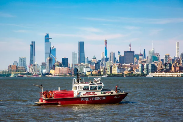 NEW JERSEY CITY, USA - MARCH 15, 2020: Jersey City Fire Department boat on the Hudson River against Manhattan cityscape background, USA