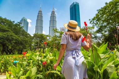 KUALA LUMPUR, MALAYSIA - 25 Şubat 2020: Kuala Lumpur, Malezya 'da güneşli bir günde Petronas Kulesi' nde kadın gezgin