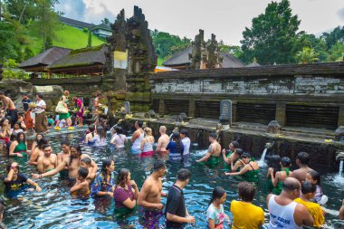 BALI, INDONEZYA - 28 Şubat 2020: Bali halkı Endonezya 'nın Bali kentindeki Pura Tirta Empul Tapınağı' ndaki kutsal havuzda dua ediyor