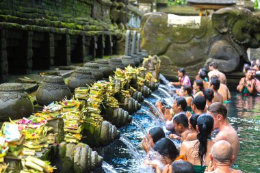 BALI, INDONEZYA - 28 Şubat 2020: Bali halkı Endonezya 'nın Bali kentindeki Pura Tirta Empul Tapınağı' ndaki kutsal havuzda dua ediyor