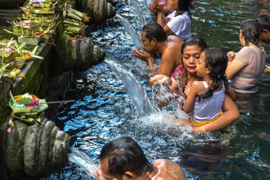 BALI, INDONEZYA - 28 Şubat 2020: Bali halkı Endonezya 'nın Bali kentindeki Pura Tirta Empul Tapınağı' ndaki kutsal havuzda dua ediyor