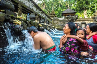 BALI, INDONEZYA - 28 Şubat 2020: Bali halkı Endonezya 'nın Bali kentindeki Pura Tirta Empul Tapınağı' ndaki kutsal havuzda dua ediyor