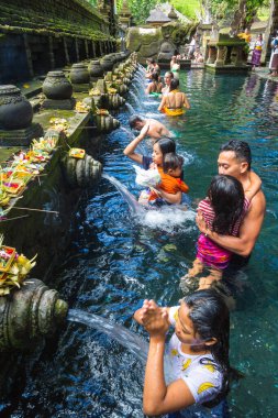 BALI, INDONEZYA - 28 Şubat 2020: Bali halkı Endonezya 'nın Bali kentindeki Pura Tirta Empul Tapınağı' ndaki kutsal havuzda dua ediyor