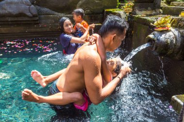 BALI, INDONEZYA - 28 Şubat 2020: Bali halkı Endonezya 'nın Bali kentindeki Pura Tirta Empul Tapınağı' ndaki kutsal havuzda dua ediyor