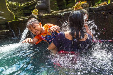 BALI, INDONEZYA - 28 Şubat 2020: Bali halkı Endonezya 'nın Bali kentindeki Pura Tirta Empul Tapınağı' ndaki kutsal havuzda dua ediyor