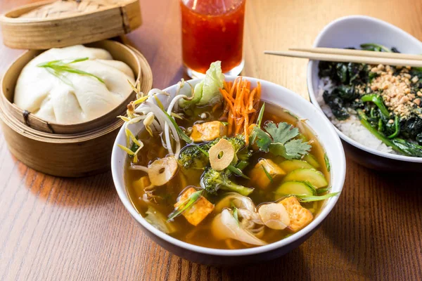 Asian dinner dishes - bao, soup and salad Royalty Free Stock Photos