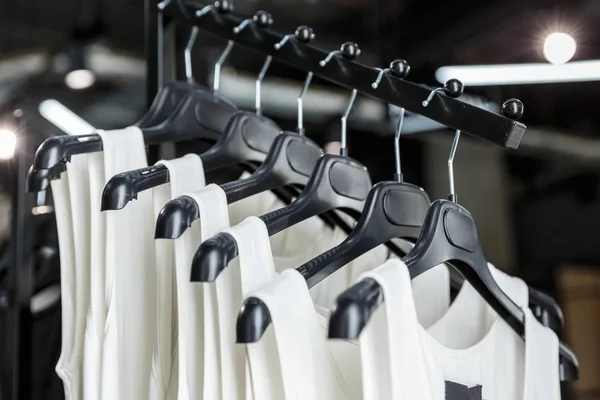 Shirts hanging on a black plastic hangers — Stock Photo, Image