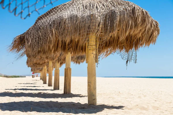 Palha guarda-chuvas artesanais em um mar — Fotografia de Stock