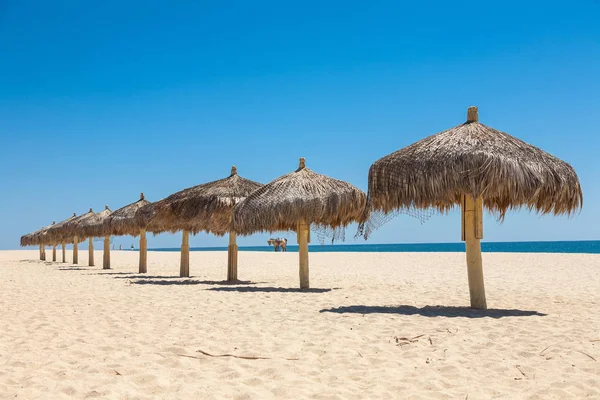 Sombrillas hechas a mano de paja en un mar —  Fotos de Stock