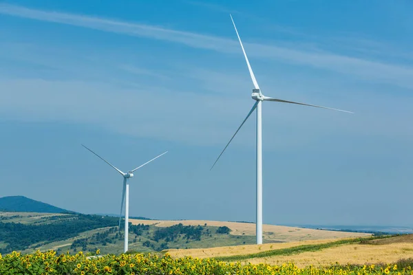 Les éoliennes debout sur un talon parmi les champs — Photo