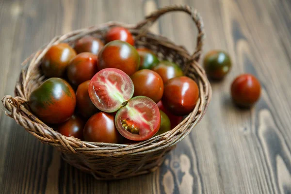 Tomates Kumato en un tazón de sauce trenzado — Foto de Stock