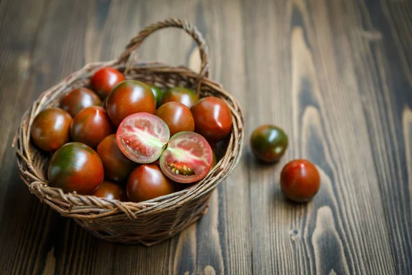 Kumatomaten in einer geflochtenen Weidenschale — Stockfoto