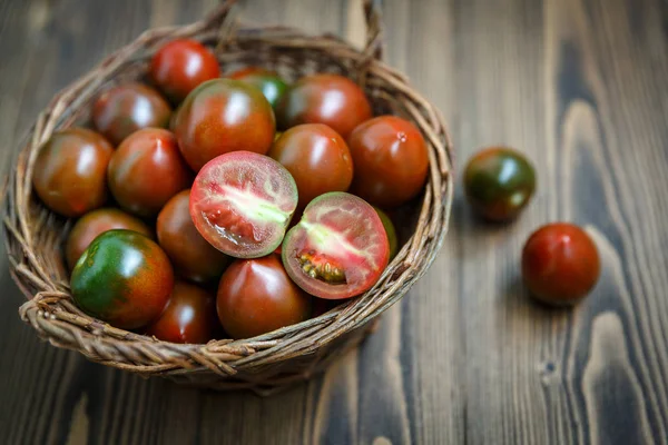 Pomodori di kumato in una ciotola di salice intrecciata — Foto Stock