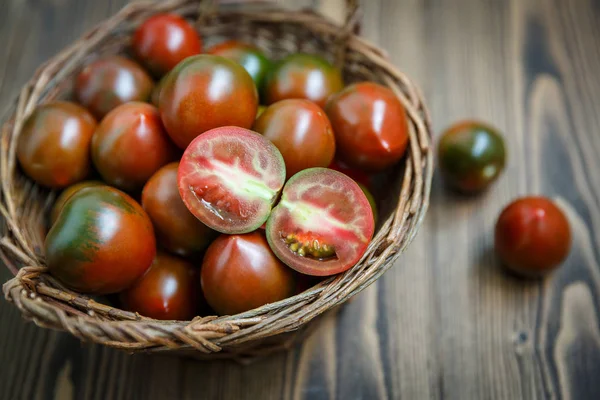 Tomates Kumato en un tazón de sauce trenzado — Foto de Stock