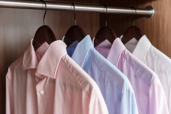 Variety of men's shirts on a wooden hangers — Stock Photo, Image