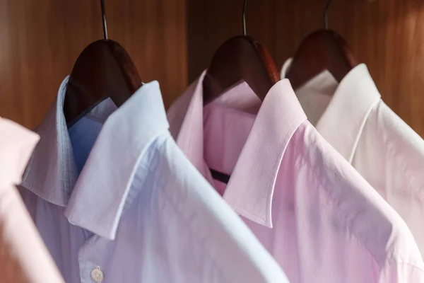 Variedad de camisas de hombre en perchas de madera — Foto de Stock