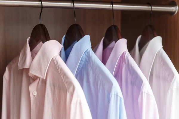 Variety of men's shirts on a wooden hangers — Stock Photo, Image