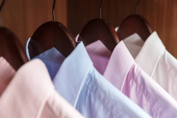 Variedad de camisas de hombre en perchas de madera — Foto de Stock