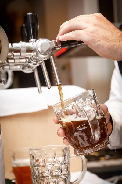Le mani del barista versano una birra artigianale alla spina in una tazza — Foto Stock