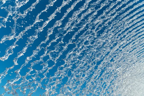 Jatos de água sobre um céu azul — Fotografia de Stock