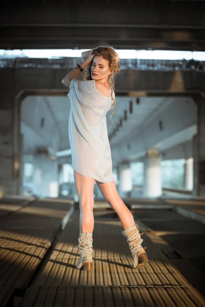 Belle jeune femme bouclée debout sur le pont industriel locati — Photo