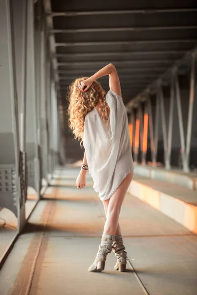 Endüstriyel Köprüsü tanıml üzerinde duran güzel kıvırcık genç kadın — Stok fotoğraf