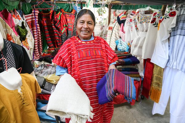 Mexican woman selling traditional mexican shawl and  clothes in 
