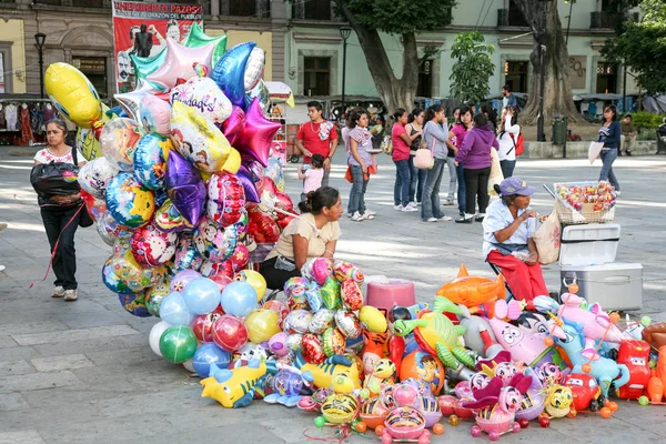 Nő értékesítés fényes színes ballonok, egy központi téren Oa — Stock Fotó