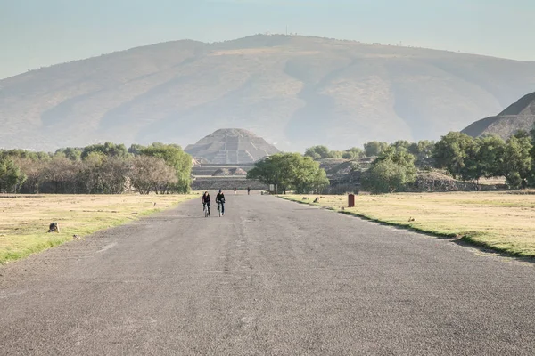 Couple à vélo tôt le matin par l'avenue epmty de — Photo