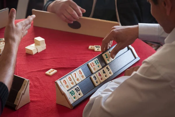 人们玩很受欢迎的逻辑桌游戏 rummikub — 图库照片