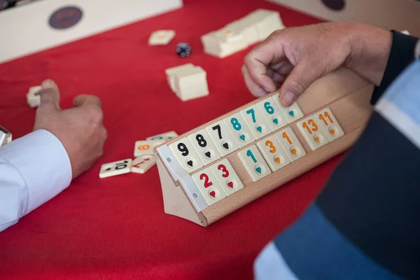 Mensen spelen populaire logica tabel spel rummikub — Stockfoto