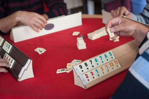 Mensen spelen populaire logica tabel spel rummikub — Stockfoto