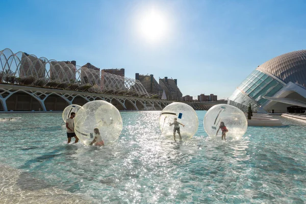 Los niños se divierten dentro de grandes globos de aire en una piscina en la ciudad o —  Fotos de Stock