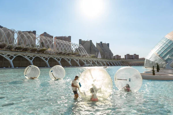 I bambini si divertono all'interno di grandi palloncini d'aria in una piscina in città o — Foto Stock