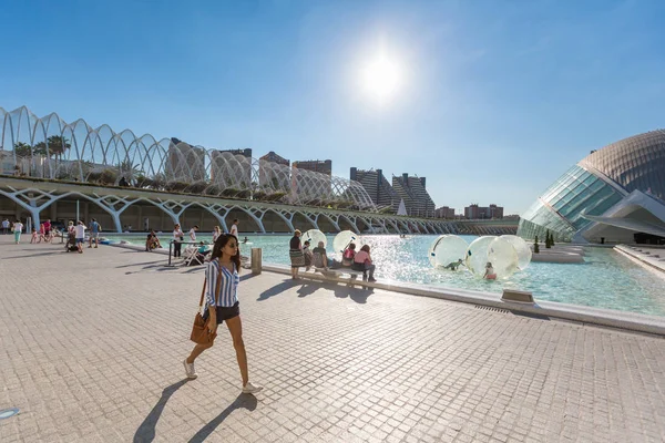 Mujer joven pasa por la piscina con la gente relajante en la ciudad de un —  Fotos de Stock