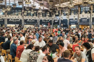 Masalarda oturan ve bir Mercado yerel yemek yeme insanlar 