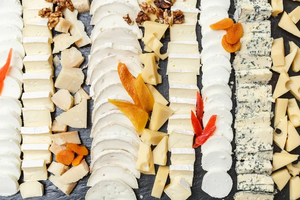 Variety of cheeses sliced on a stone plate