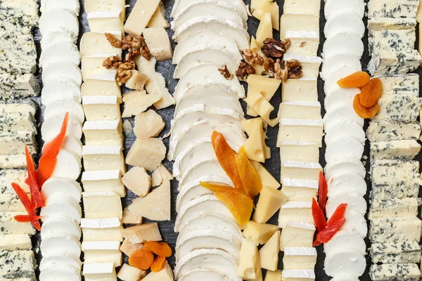 Variedad de quesos rebanados en un plato de piedra — Foto de Stock