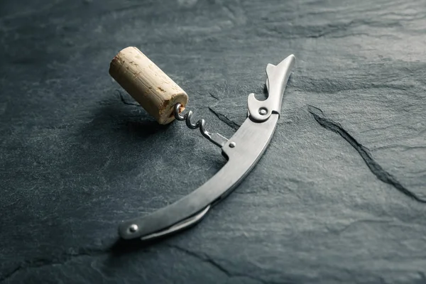 Stainless  wine corkscrew with a cork on a rocky slate backgroun — Stock Photo, Image