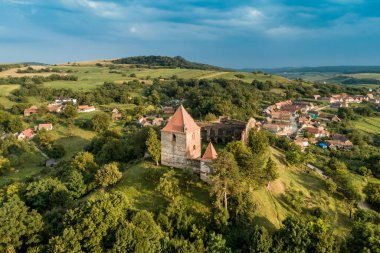 Aerial drone view of Slimnic Fortress (Stolzenburg), located on a Burgbasch hill on a Sibiu road in Transilvania, Romania. Travel spots in Romania clipart