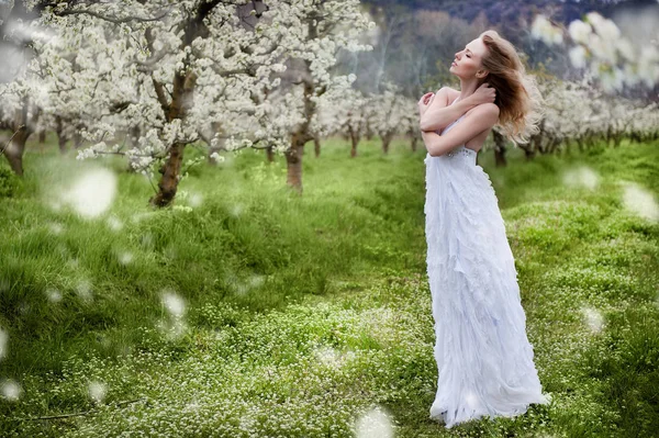 Mooi meisje in een bloeiende lentetuin — Stockfoto