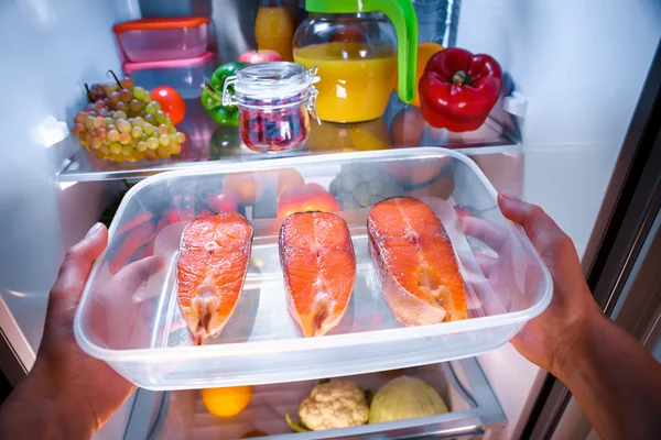 Raw Salmon steak in the open refrigerator