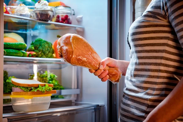 Hongerige vrouw houdt van een been van Turkije in zijn handen en permanent volgende — Stockfoto