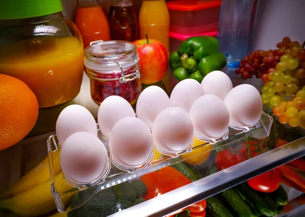 Chicken eggs on a shelf open refrigerator — Stock Photo, Image