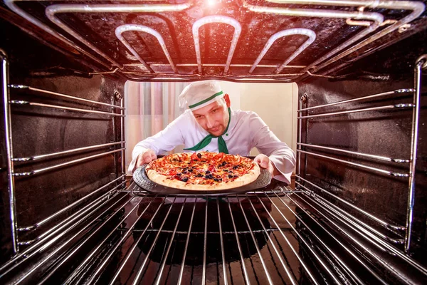 Kuchař vaření pizza v peci. — Stock fotografie