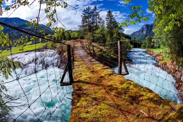 Puente colgante sobre el río de montaña, Noruega . — Foto de Stock