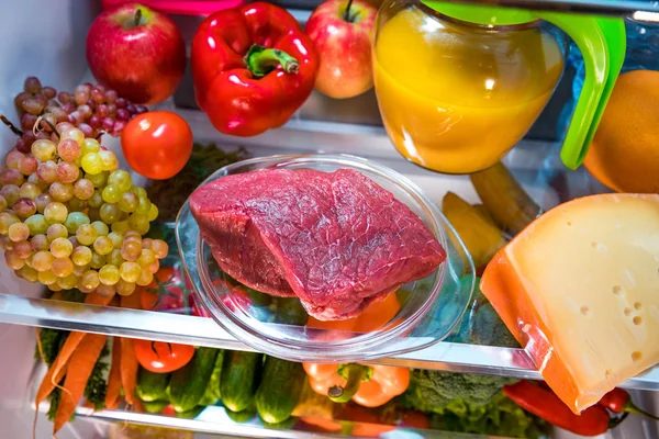 Свежее сырое мясо на полке открытого холодильника — стоковое фото